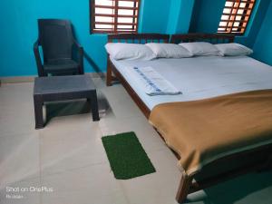 a bedroom with a bed and a chair and a green rug at Totadamane in murdeshwar in Māvalli +21 photos