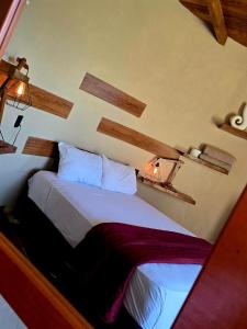 a bedroom with a bed and two lights on the wall at Domo Abitare Glamping in Isla de Mezcala