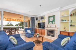 a living room with blue couches and a fireplace at Villa Dori by Villa Select in Punta Prima