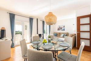 a dining room and living room with a table and chairs at Estrella Del Mar with Private Pool in Binibeca
