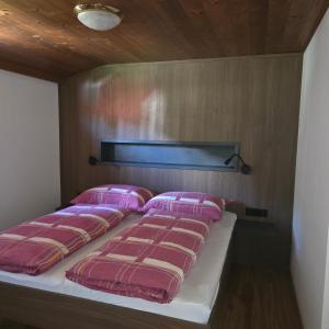 a bed in a room with pink pillows on it at Merlschober, Ferienwohnung 8, Ossiacher See in Ossiach