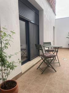 a patio with two chairs and a table and a plant at Apartamento Casa Nela 3 in Medellín