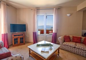 a living room with a couch and a tv at Lourdas Beach View by Villa Select in Lourdata