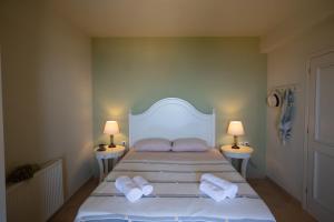 a bedroom with a bed with two pillows and two lamps at Lourdas Beach View by Villa Select in Lourdata +16 photos