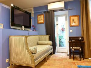 a living room with a couch and a tv on the wall at Alcôve Marine in Gruissan