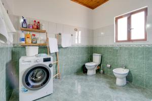 a bathroom with a washing machine and a toilet at Villa Kevin in Berat +24 photos