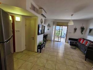 a living room with a couch and a tv at shohamseaview in Eilat