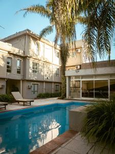 a building with a swimming pool in front of a building at Mercedes Park Hotel in Villa Mercedes
