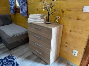 a wooden dresser with a pile of towels on it at Etno kutak Milojevic in Paraćin +32 photos