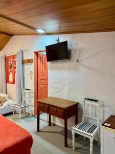 a room with a table and a tv on a wall at Pousada Mirante das Fitas in Arraial d'Ajuda