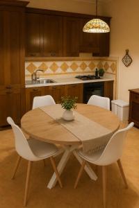 a kitchen with a wooden table and white chairs at Villa Fabi in Brindisi