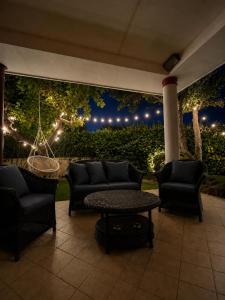 a patio with couches and a table and lights at Villa Fabi in Brindisi