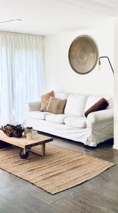 a living room with a white couch and a coffee table at Prive rustplek op de Veluwe met jacuzzi in Ermelo