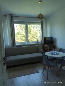 a living room with a couch and a table and a window at pokoje do wynajecia in Giżycko