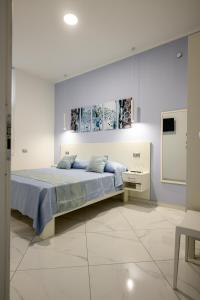 a white bedroom with a bed and a tv at Al 211 Rooms in Pizzo