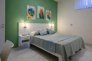 a bedroom with a bed and a green wall at Al 211 Rooms in Pizzo