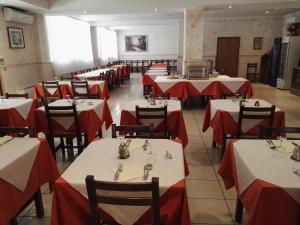 a dining room with red and white tables and chairs at Hotel Trasimeno Bittarelli in Castiglione del Lago