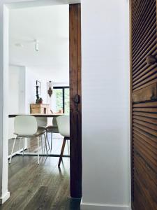 a dining room with white walls and a table and chairs at Prive rustplek op de Veluwe met jacuzzi in Ermelo