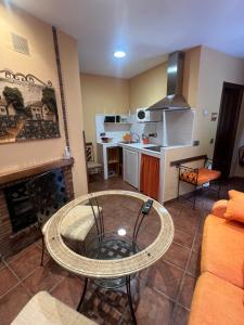 a living room with a table and a kitchen at Apartamentos La Guergola in Pola de Somiedo