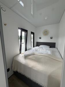 a white bed in a room with a window at Design-Hausboot am Rheinsteig in Lorch am Rhein