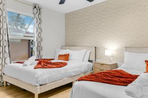 a bedroom with two beds and a window at Splash & Relax Games WiFi BBQ Fire Pit Boat Lake in Royal Palm Beach