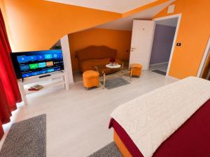 a bedroom with a bed and a table and a television at Hotel Kamelia in Varna City