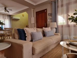 a living room with a couch with pillows on it at MD Villa con piscina en Mareny Beach in Mareny Blau