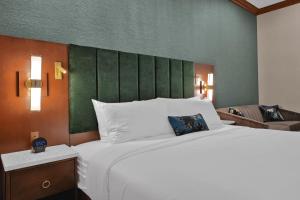 a bedroom with a large white bed with a green headboard at The Miners 1928 Hotel in Pottsville +26 photos