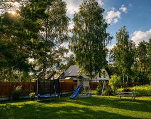 a yard with a playground with a slide at Leśny Apartament I in Szczytno +2 photos