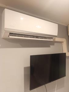 a flat screen tv hanging from a ceiling at Studio charmant in Sedan