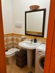 a bathroom with a sink and a toilet and a mirror at Villa Fabi in Brindisi +8 photos