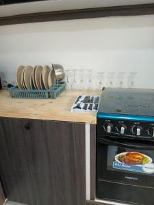 a kitchen counter with a stove and plates and glasses at L'hospitalité in Thies +2 photos