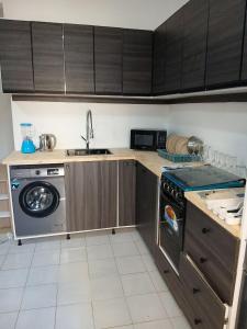 a kitchen with a stove and a washing machine at L'hospitalité in Thies