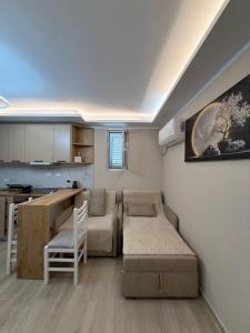 a small apartment with a couch and a kitchen at Alea Home in Fier
