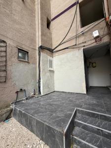 a building with a concrete floor next to a building at Alea Home in Fier