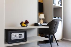 a room with a desk with a microwave and a chair at Small Guesthouse in Bussolengo
