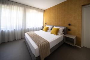 a bedroom with a large bed with yellow pillows at Small Guesthouse in Bussolengo