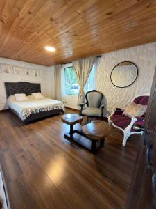 a bedroom with a bed and a chair and a table at Vereda San Jorge Chalet in Zipaquirá