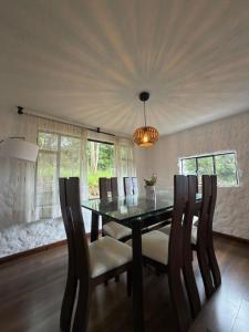 a dining room with a table and chairs and a chandelier at Vereda San Jorge Chalet in Zipaquirá