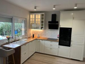 a kitchen with white cabinets and a sink at Apartman LaVida in Kaštela