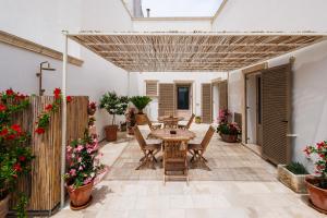 a patio with a table and chairs and flowers at Miria B&B in Castrignano del Capo