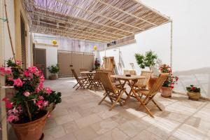 a patio with a table and chairs and flowers at Miria B&B in Castrignano del Capo +179 photos