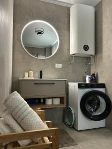 a bathroom with a washing machine and a mirror at Apartman LaVida in Kaštela