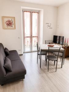 a living room with a couch and a table at Lescen White Residence - Lake View in Lezzeno