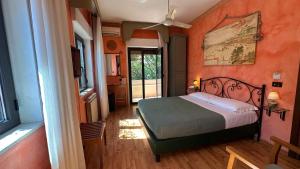 a bedroom with a bed with an orange wall at Villa Morgana Resort and Spa in Torre Faro +55 photos