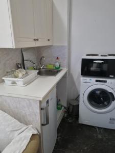 a kitchen with a sink and a washing machine at Calma2 in Agioi Theodoroi