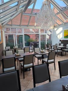 ein Restaurant mit Tischen und Stühlen und einem Kronleuchter in der Unterkunft Da‘ Amici in Horstmar