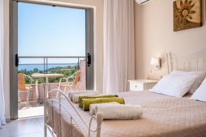 a white bedroom with a bed and a balcony at Villa Anna by Villa Select in Skala +35 photos