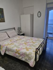 a bedroom with a bed with a flowered comforter at Calma2 in Agioi Theodoroi