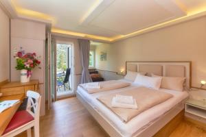 a bedroom with a large bed with a table and a desk at Rhein Hotel Bacharach und Stübers Restaurant in Bacharach